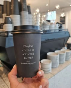 a person holding up a coffee cup that says maybe coffee is adicted to me