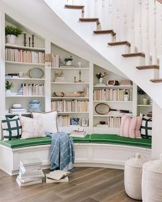 a room with bookshelves, pillows and other items on the shelves in it