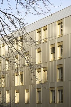 an apartment building with many windows and trees in the foreground