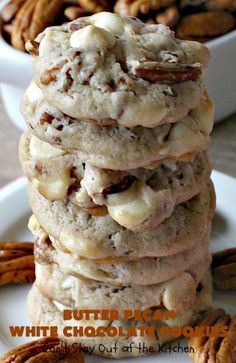 a stack of cookies with white chocolate and pecans in the background on a plate