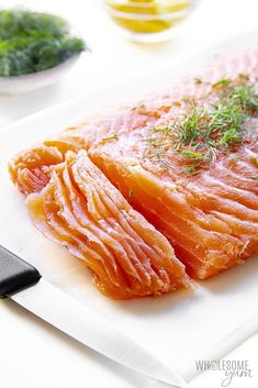 raw salmon on a cutting board with herbs