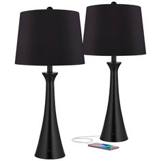 two black lamps next to each other with a phone plugged into the lamp holder