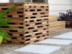 a planter made out of wooden pallets next to some plants