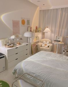 a white bed sitting in a bedroom next to a dresser and chair with two lamps on top of it