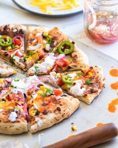 a pizza sitting on top of a pan covered in cheese and veggie toppings