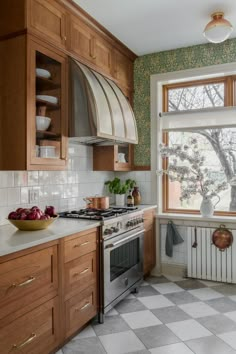 a kitchen with wooden cabinets and white tile flooring is pictured in this image, there are dishes on the stove