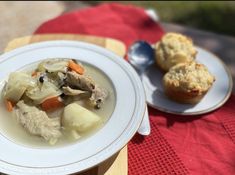 a bowl of soup and muffins on a table