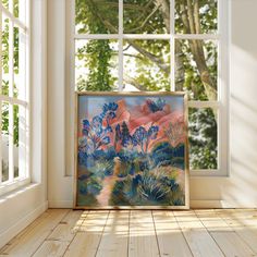 a painting is sitting in front of a window on the floor next to an open door