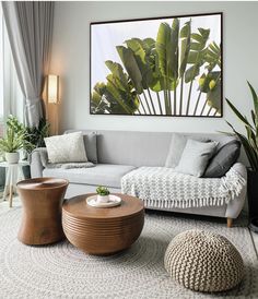 a living room filled with furniture next to a large window covered in green leaves and trees