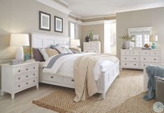 a white bed sitting in a bedroom next to a dresser and mirror on top of a wooden floor