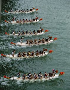 a group of people riding on top of boats in the water