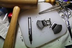 various crafting tools are sitting on a cutting board