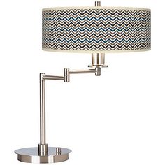 a table lamp with a blue and white fabric shade on the base, next to a silver metal stand