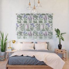 a bedroom with a large painting hanging above the bed and plants on the wall behind it