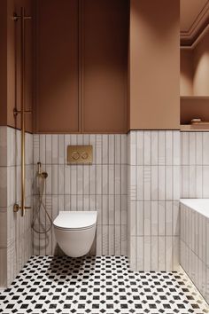 a bathroom with black and white tiles on the floor, brown walls and gold fixtures