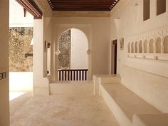 an empty hallway with white walls and arches