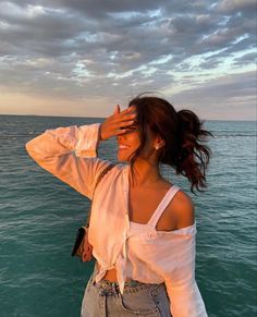 a woman standing on top of a boat near the ocean