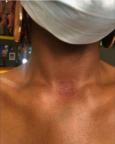 a man with a tattoo on his chest has a small symbol in the middle of his chest