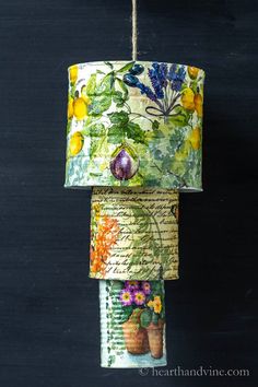 three rolls of fabric hanging from a string with flowers and leaves printed on them,