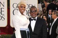 a man and woman standing next to each other in front of people on the red carpet