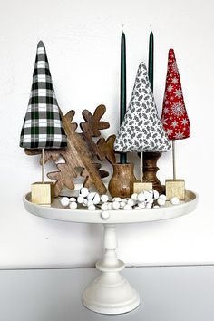 a white cake plate topped with wooden christmas trees