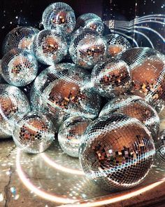 a pile of shiny disco balls sitting on top of a floor next to each other