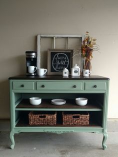 a green table with two baskets on it and some coffee cups sitting on top of it