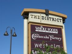 the sign for the whole foods cheesecake factory in front of a blue sky background