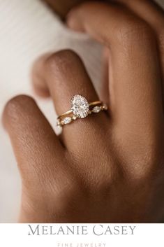 a woman's hand with a diamond ring on her finger and the text melanie casey fine jewelry