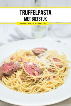 a white plate topped with spaghetti and meat