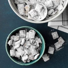 two bowls filled with sugar cubes on top of a blue table cloth next to each other