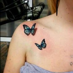 two blue butterflies on the back of a woman's left shoulder and upper arm