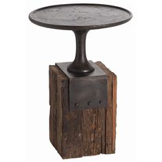 an iron and wood side table on top of a piece of wood with a metal base