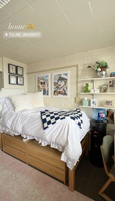 a bedroom with a bed, desk and shelves on the wall above it is shown