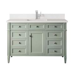 a bathroom vanity with white counter top and two sinks on each side, in green