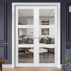 a living room with two doors that open to the dining room and sitting area in front of it