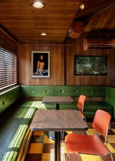 the inside of a restaurant with green booths and checkered flooring on the walls