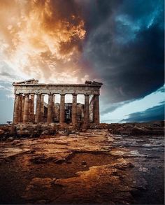 the ruins of an ancient greek temple under a cloudy sky