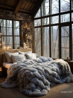 a large bed sitting in front of a window filled with lots of pillows and blankets