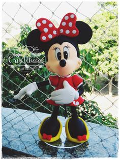 a mickey mouse figurine sitting on top of a table next to a fence