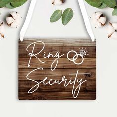 a sign that says ring and security on it next to some cotton flowers with leaves