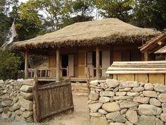 a small hut with thatched roof and stone walls