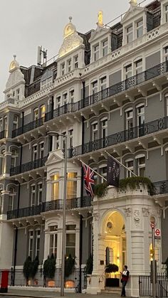 a large building with many balconies on it's sides and an union jack flag hanging from the balcony