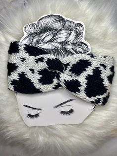 a black and white headband with an animal print bow on it, sitting next to a