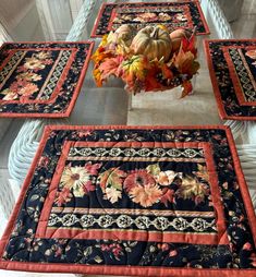 four quilted placemats with flowers in a vase on top of each one