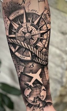 a man's arm with a compass and world map tattoo on the left forearm