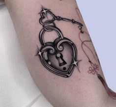 a woman with a tattoo on her arm has a lock and key in the shape of a heart