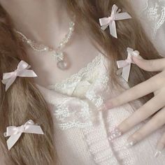 a close up of a person with long hair wearing pearls and bows on her necklace