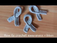 two crochet awareness ribbons sitting on top of a wooden table with the words how to crochet awareness ribbon