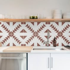 a kitchen with white and brown tiles on the wall